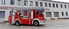 Podnośnik hydrauliczny 421[O]53 zaparkowany przed budynkiem JRG 1 PSP, z widoczną drabiną i zimową scenerią wokół jednostki.