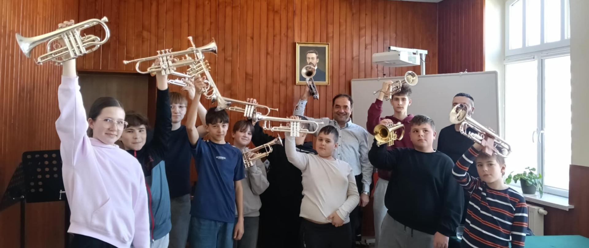 młodzi uczniowie klasy trąbki wraz z nauczycielami podczas warsztatów