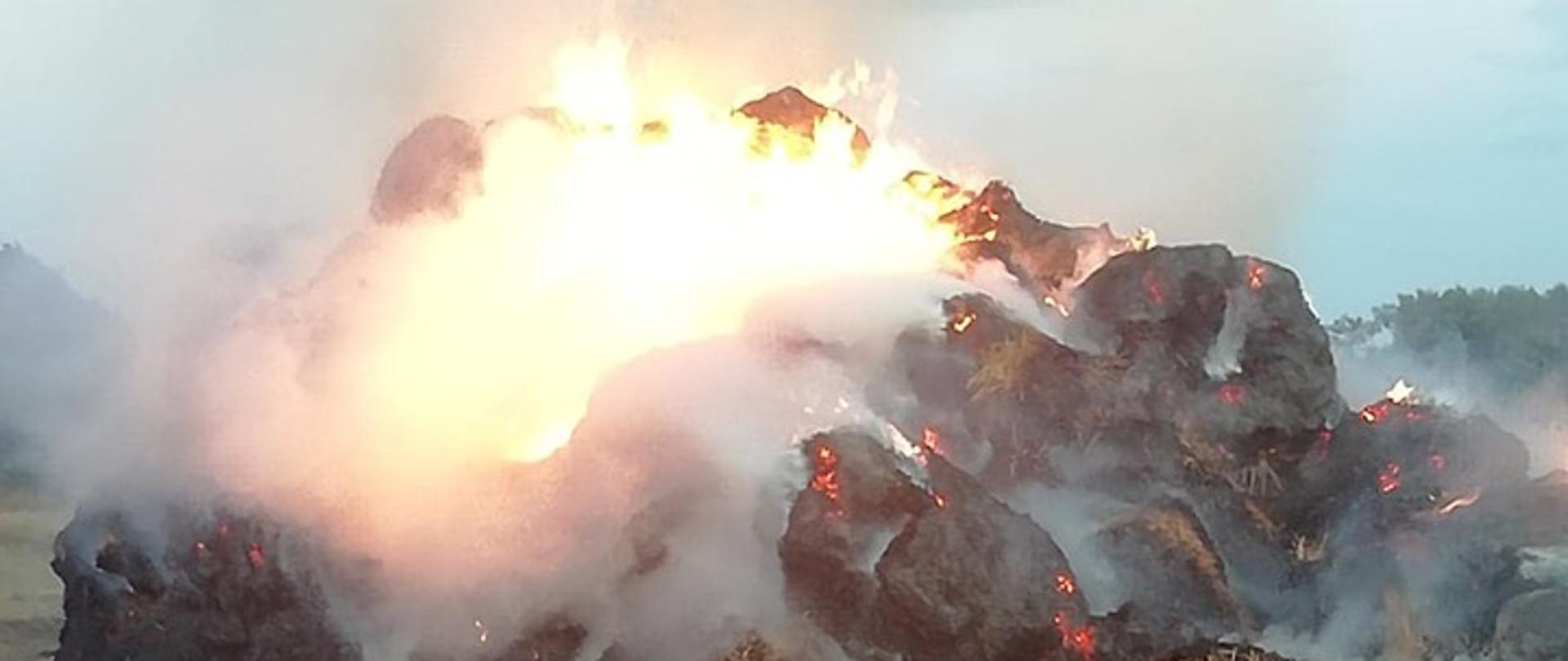 Na polu widać palący się stóg słomy