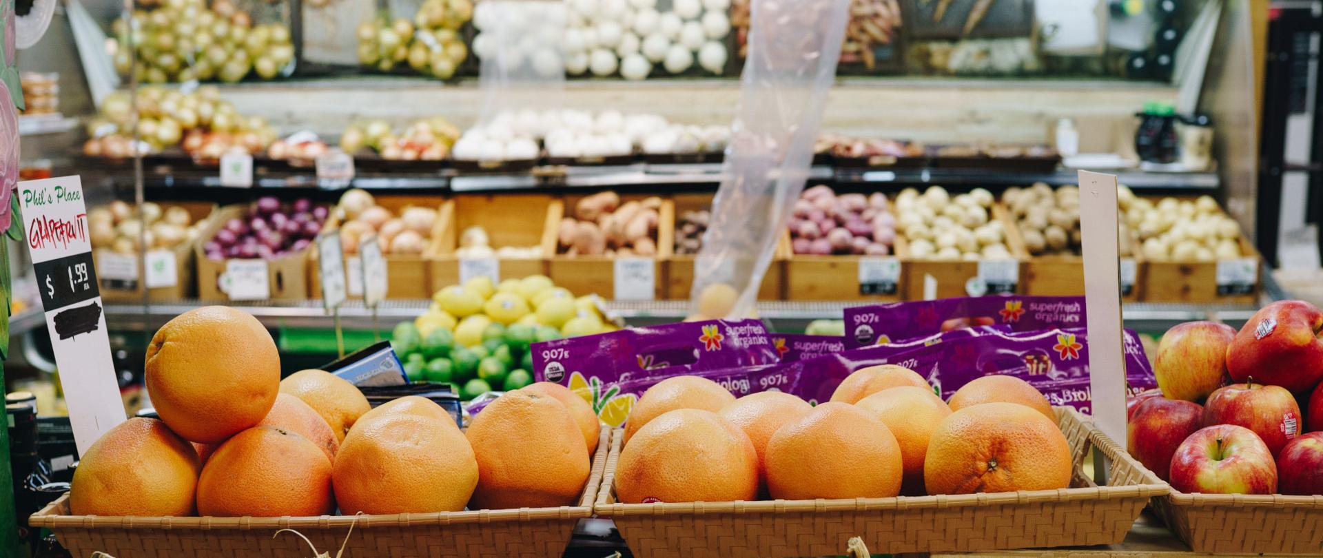 Fotografia przedstawiająca stoisko z owocami i warzywami w supermarkecie