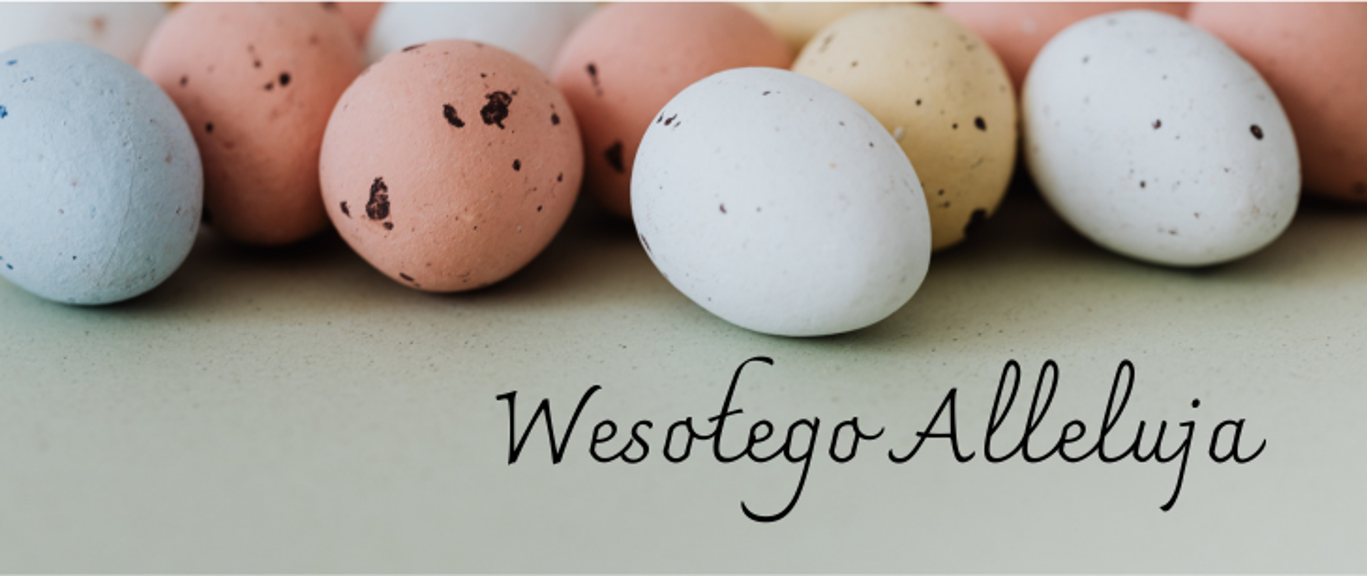 Szare tło w górnej części pisanki koloru jasno niebieskiego, różowego oraz białego, poniżej napis Wesołego Alleluja