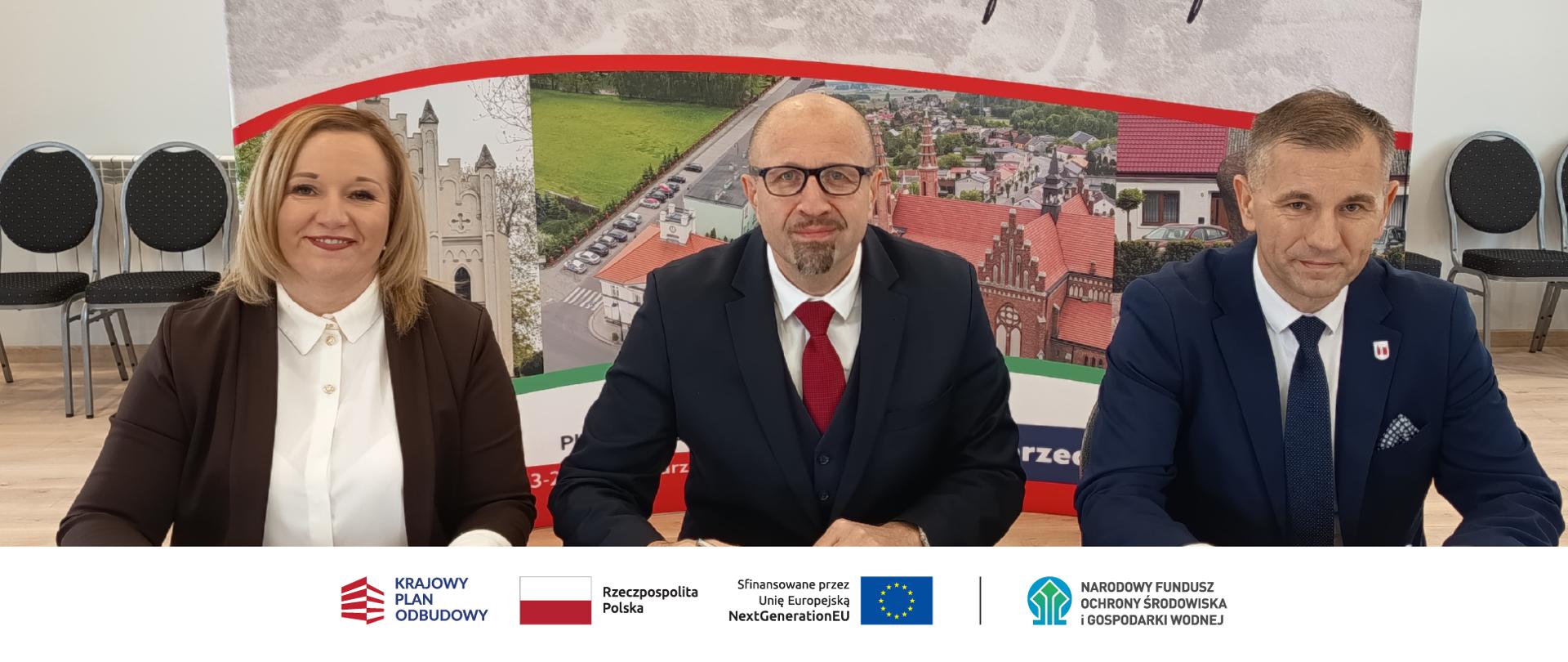 Zdjęcie grupowe. Na zdjęciu kobieta i dwaj mężczyźni. W stopce zdjęcia ciąg logotypów: Krajowy Plan Odbudowy, flaga Rzeczypospolita Polska, flaga UE Sfinansowane przez UE NextGenerationUE, NFOŚiGW.