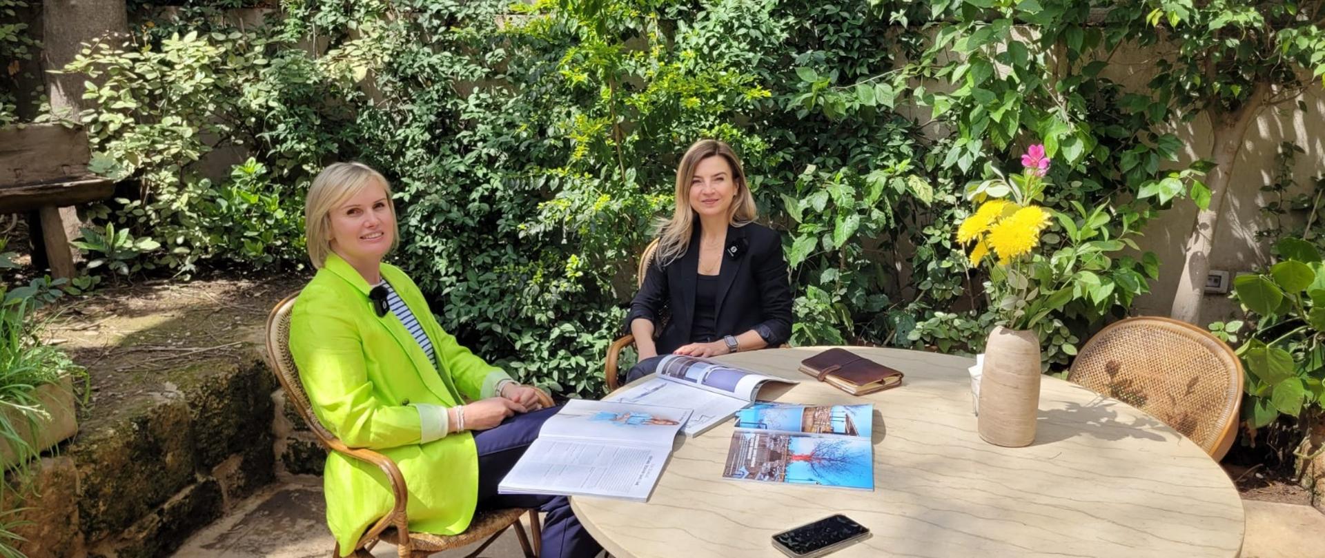 Dwie kobiety siedzą przy stoliku w restauracji.