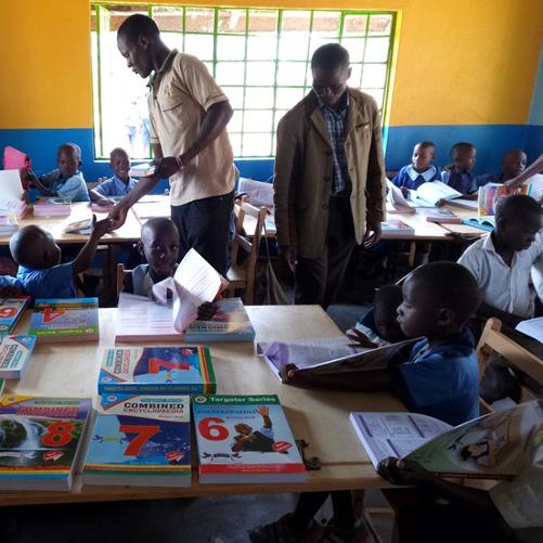 Dzieci w szkole z opiekunami przeglądają podręczniki