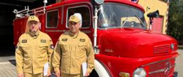 Kapitan Mariusz Wołowski- Dowódca Jednostki Ratowniczo-Gaśniczej i Brygadier Marek Szymanek- Naczelnik Wydziału Operacyjno-Technicznego stoją przy zabytkowym samochodzie ratowniczo-gaśniczym marki mercedes