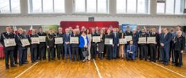 Wspólne zdjęcie grupowe uczestników uroczystości przekazania promes na dofinansowanie zakupu samochodów ratowniczo-gaśniczych dla jednostek OSP województwa opolskiego