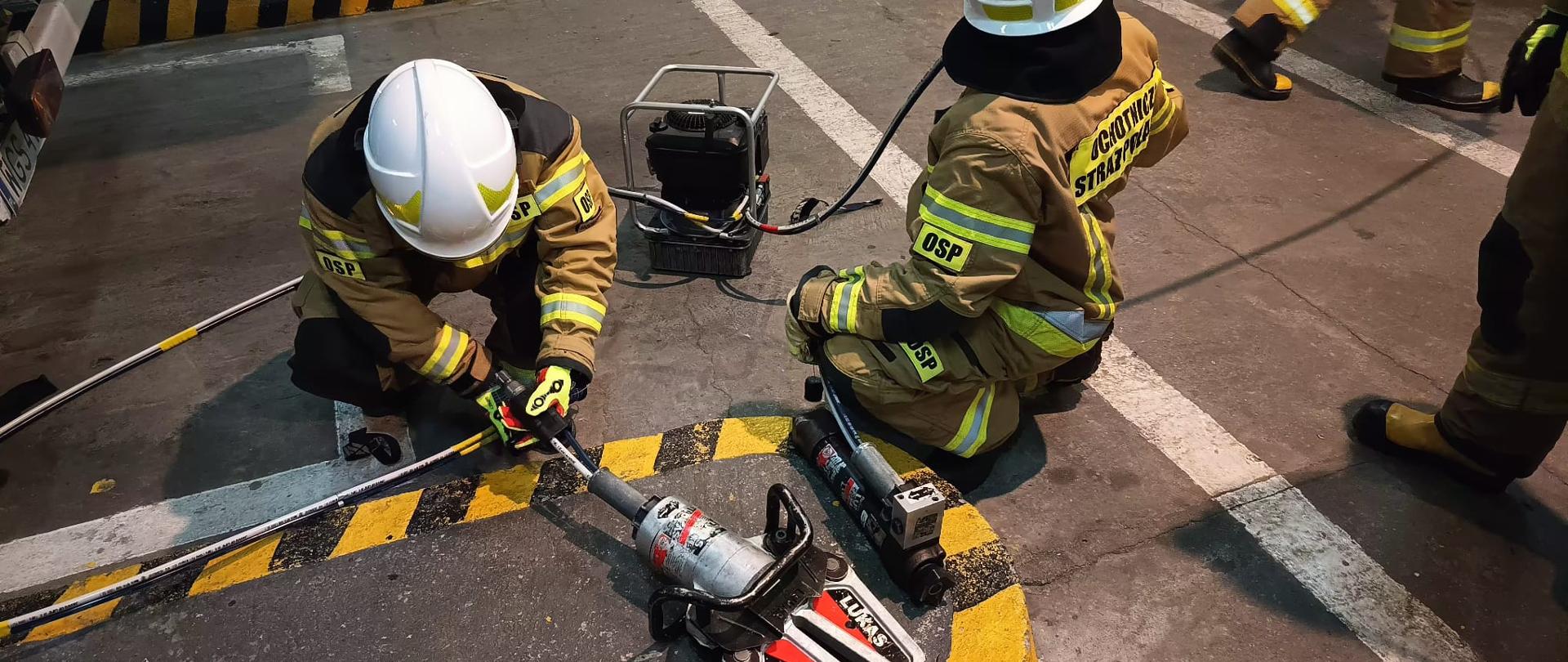 Na zdjęciu strażacy OSP używający sprzęt z ratownictwa techniczmego 