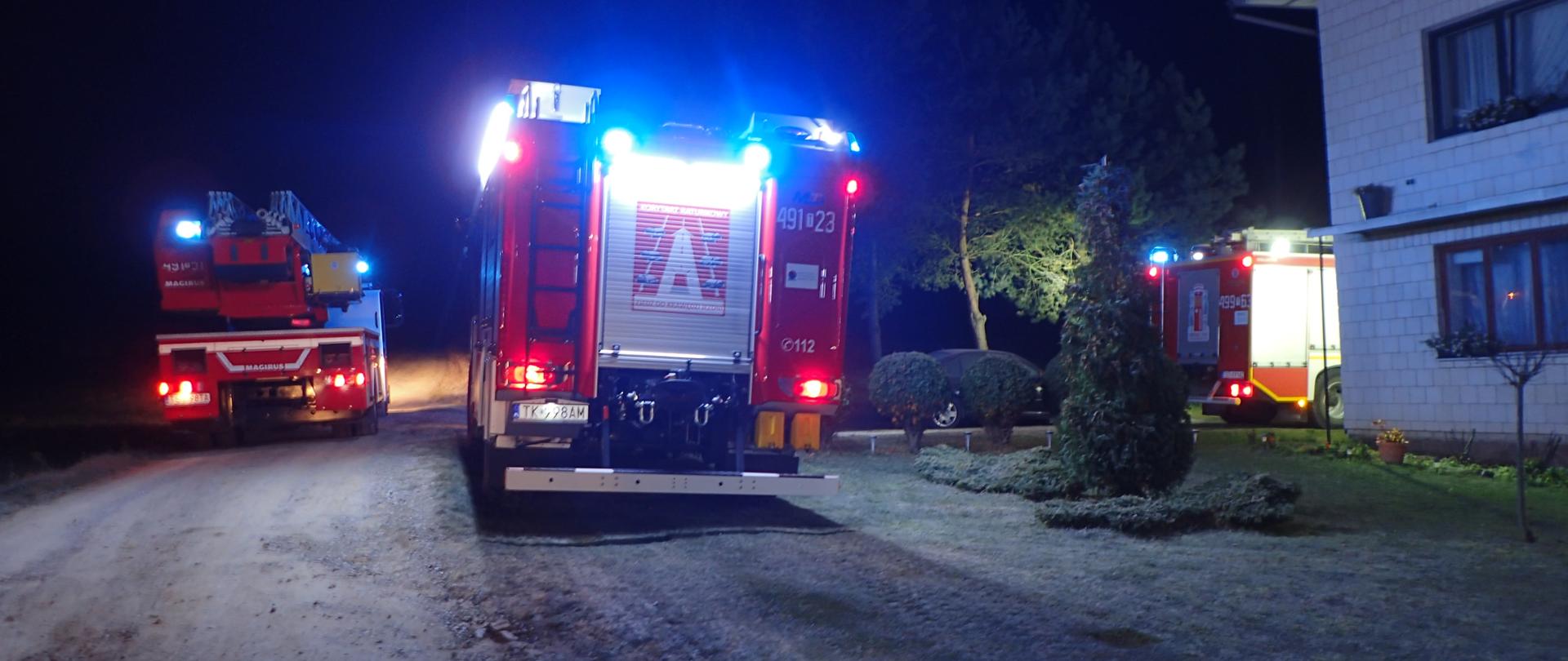 Samochody pożarnicze przy budynku mieszkalnym pora nocna