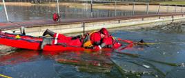 Na zdjęciu widać strażaków z saniami lodowymi na zamarzniętym akwenie podczas ćwiczeń.