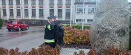 Delegacja strażaków składająca hołd przed pamiątkowym obeliskiem za strażaków