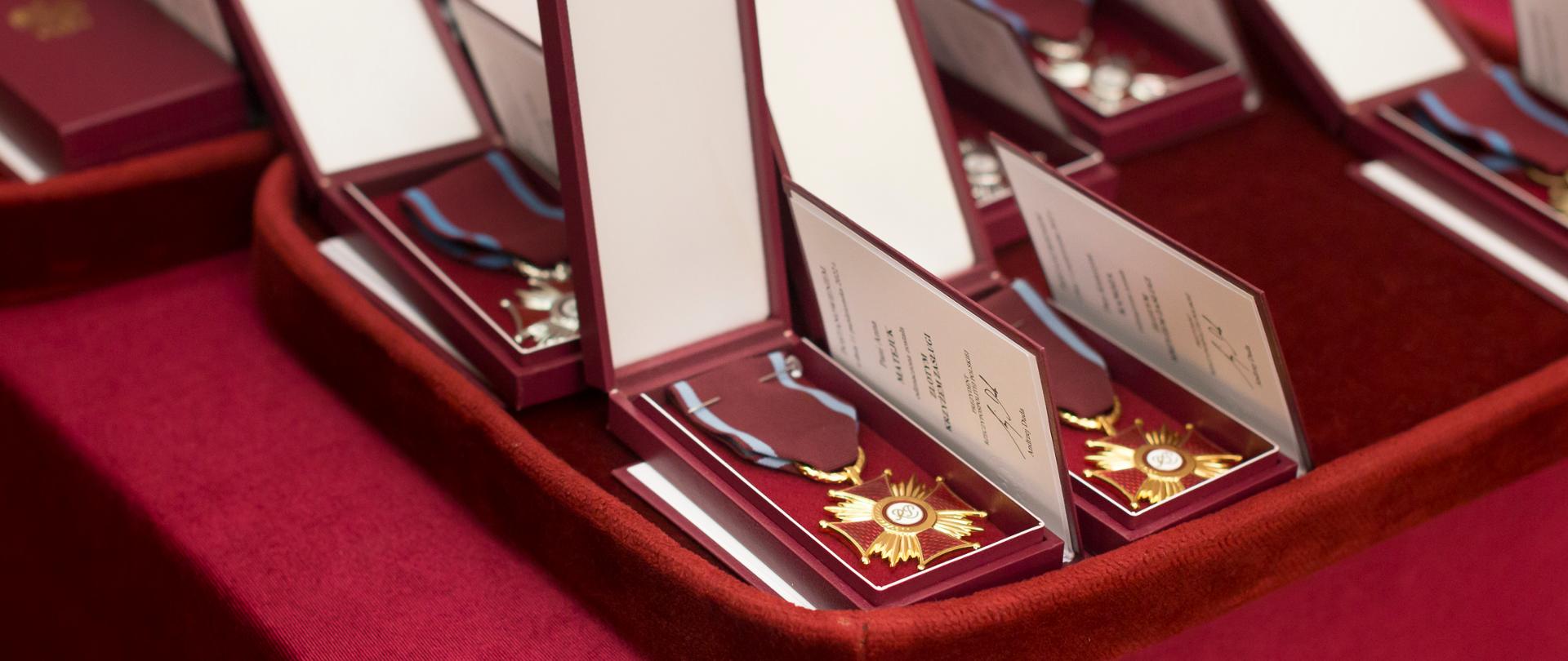 złote medale leżące na podkładce 