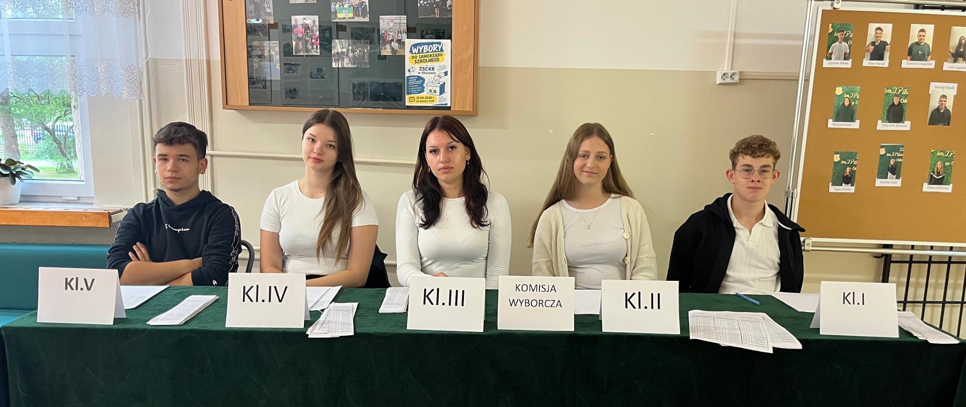 Członkowie szkolnej komisji wyborczej przy stoliku podczas wyborów samorządu uczniowskiego