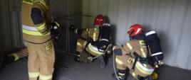 Strażacy ćwiczą przeszukanie pomieszczenia.