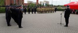 Zdjęcie przedstawia strażaków stojących na placu przed budynkiem komendy podczas obchodów dnia strażaka