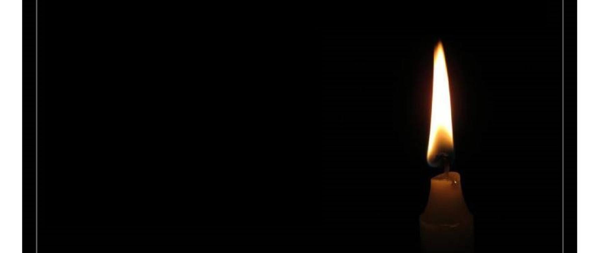 Paląca się świeca na czarnym tle