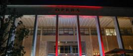The opera house is illuminated in red and white