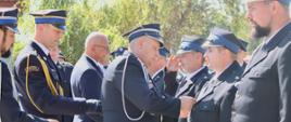 Komendant Powiatowy PSP (lekko z lewej) oraz Komendant Gminny wręczają wyróżnienia i nagrody.
