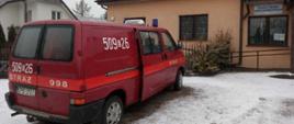 Czerwony samochód strażacki lekki typu BUS z numerami operacyjnym 509 26 na tle budynku Ośrodka Zdrowia 