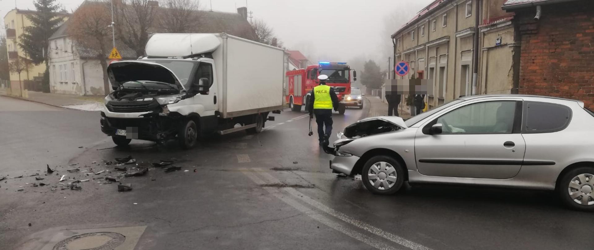 Na zdjęciu widać rozbite pojazdy na skrzyżowaniu policjanta oraz wóz strażacki 