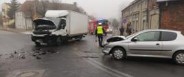 Na zdjęciu widać rozbite pojazdy na skrzyżowaniu policjanta oraz wóz strażacki 