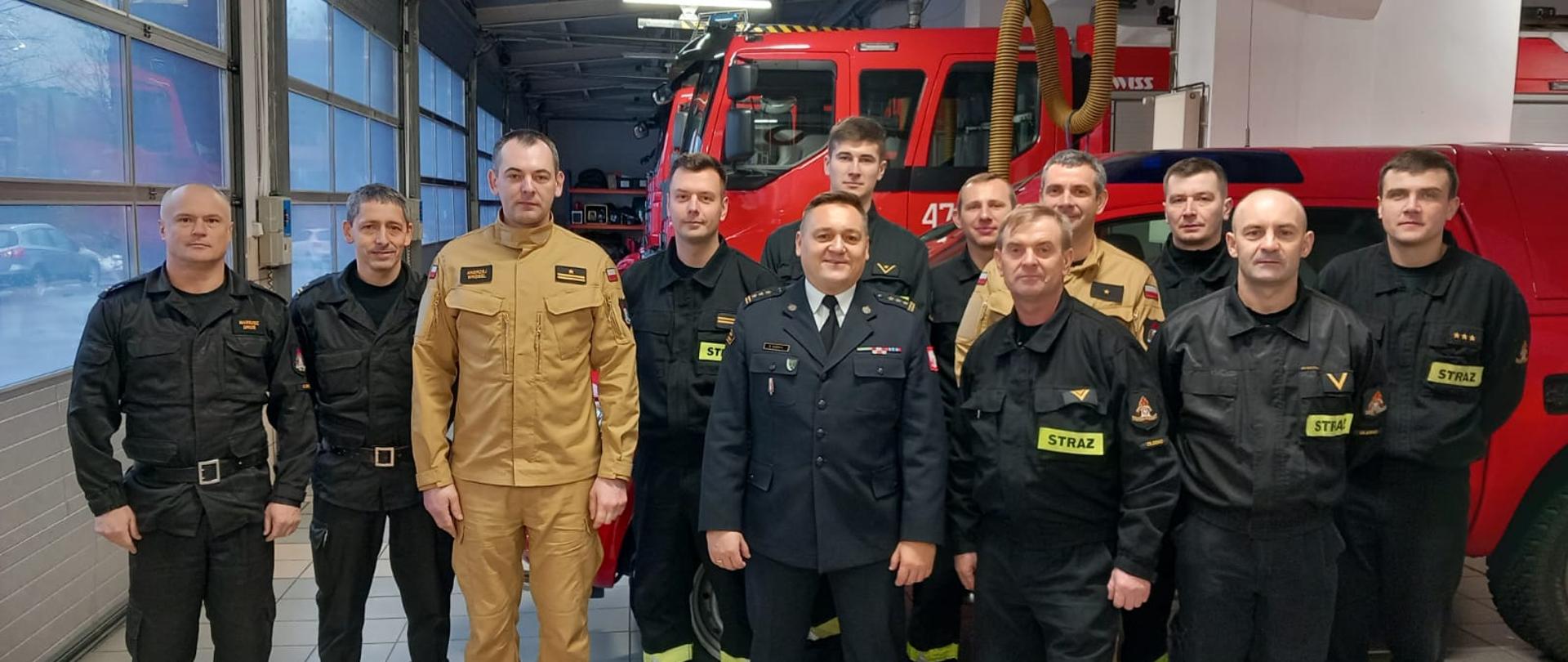 Na zdjęciu Opolski Komendant Wojewódzki PSP, Komendant Powiatowy PSP wraz z zastępcą,
dowódca JRG wraz z strażakami pełniącymi w tym dniu służbę na garażu. W tle samochody pożarnicze.