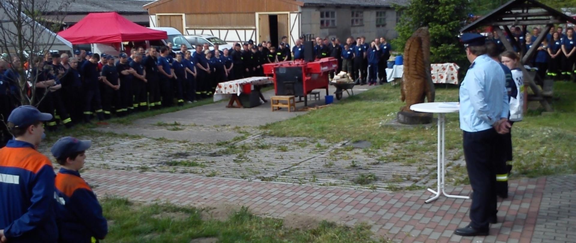 Zdjęcie przedstawia zbiórkę strażaków na placu przed ćwiczeniami