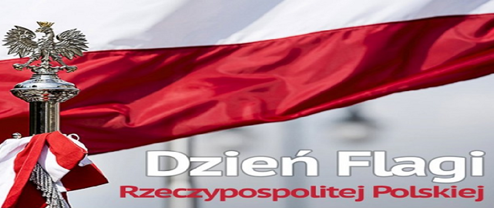 Na zdjęciu widać napis w kolorystyce biało czerwonej "Dzień Flagi Rzeczypospolitej Polskiej na tle fragmentu flagi państwowej . Z lewej strony widoczny na drzewcu zakończonym metalowym okuciem orzeł .