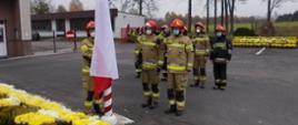 Zdjęcie przedstawia strażaków JRG KP PSP Kłobuck podczas podniesienia flagi państwowej oraz wspólnego odśpiewania hymnu.