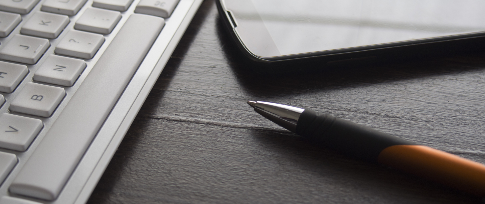 Klawiatura komputera, telefon oraz długopis