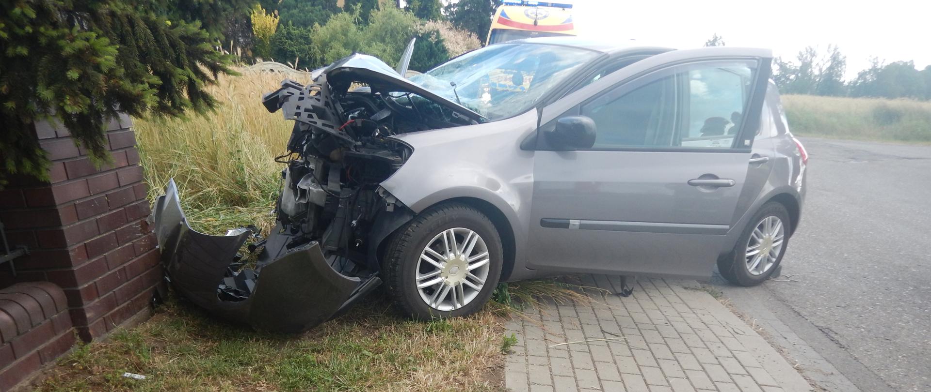 Zdjęcie przedstawia samochód osobowy, który brał udział w zdarzeniu. Samochód ma rozbity przód oraz pękniętą szybe.