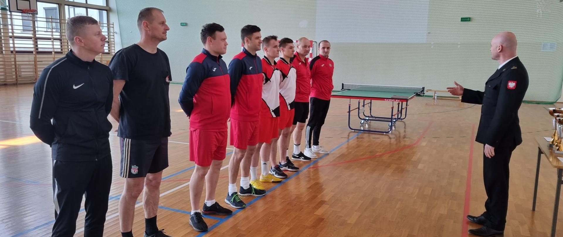 Komendant powiatowy PSP w Jędrzejowie mł. bryg. Mariusz Stolarczyk, który przemawia do ustawionych w szeregu zawodników po zakończeniu rozgrywek