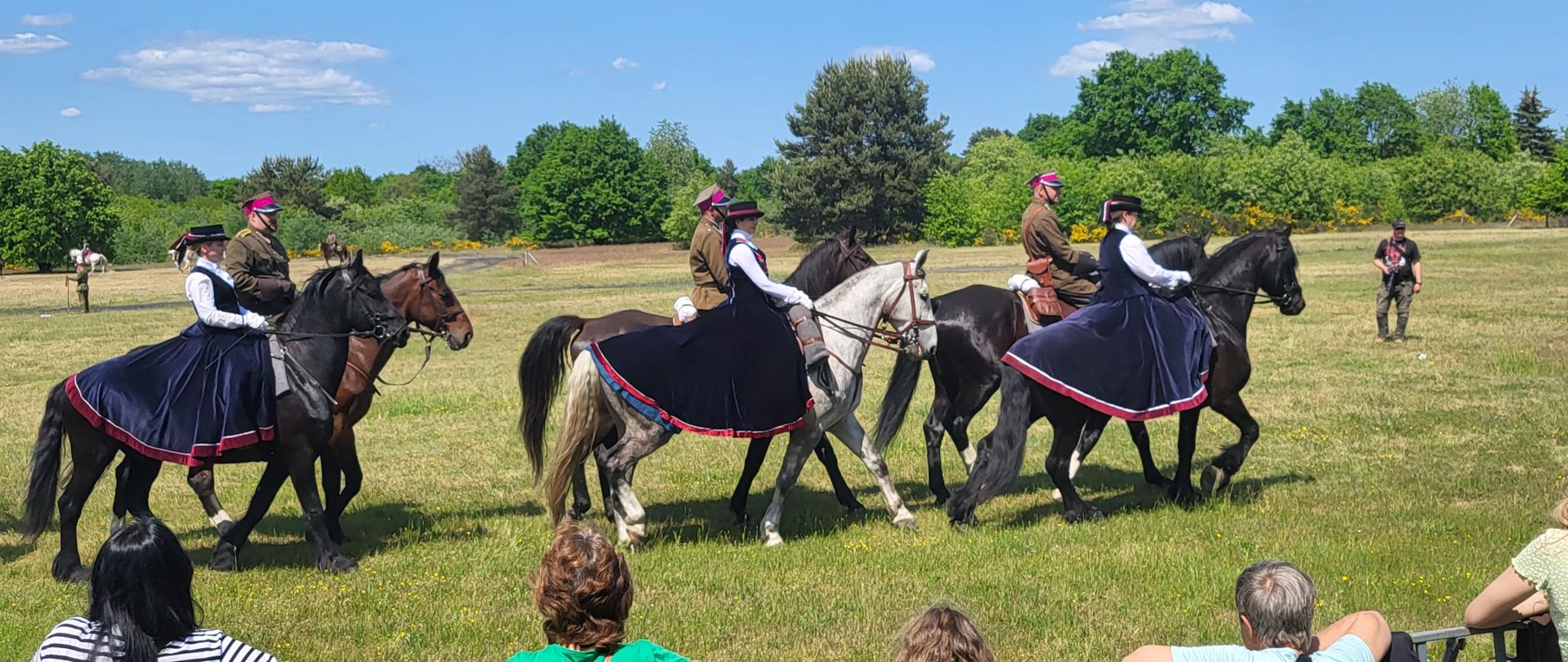 Grupa ludzi jadących na grzbietach koni
