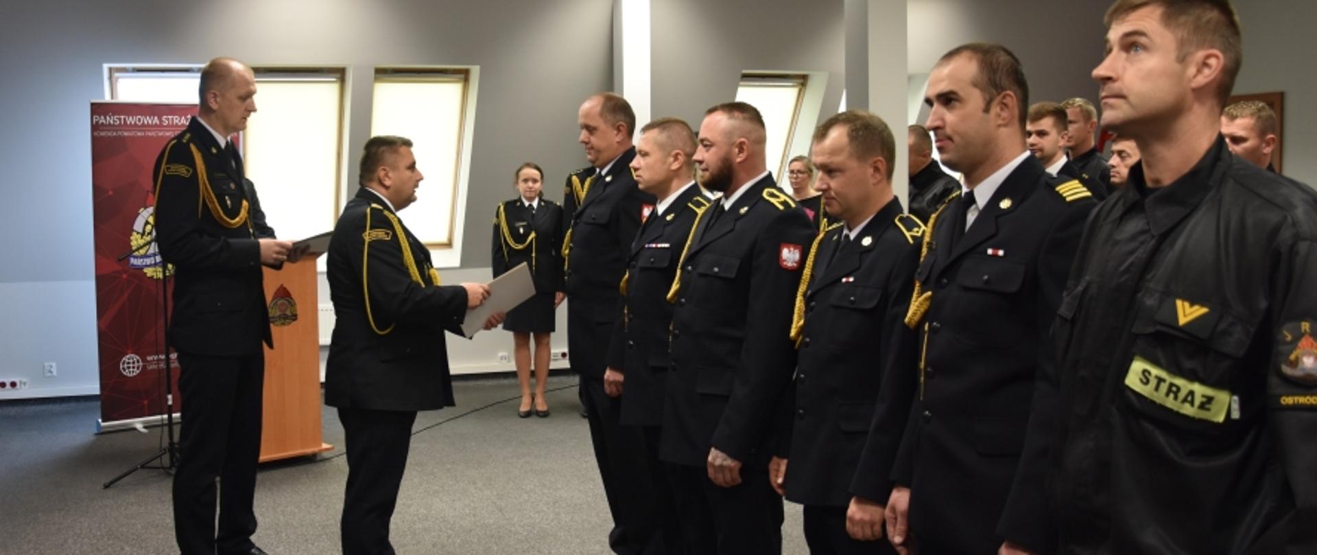 Komendant wręcza decyzje o awansach. 