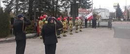Zdjęcie przedstawia funkcjonariuszy KM PSP Olsztyn w trakcie uroczystych zbiórek z podniesieniem flagi państwowej na maszt