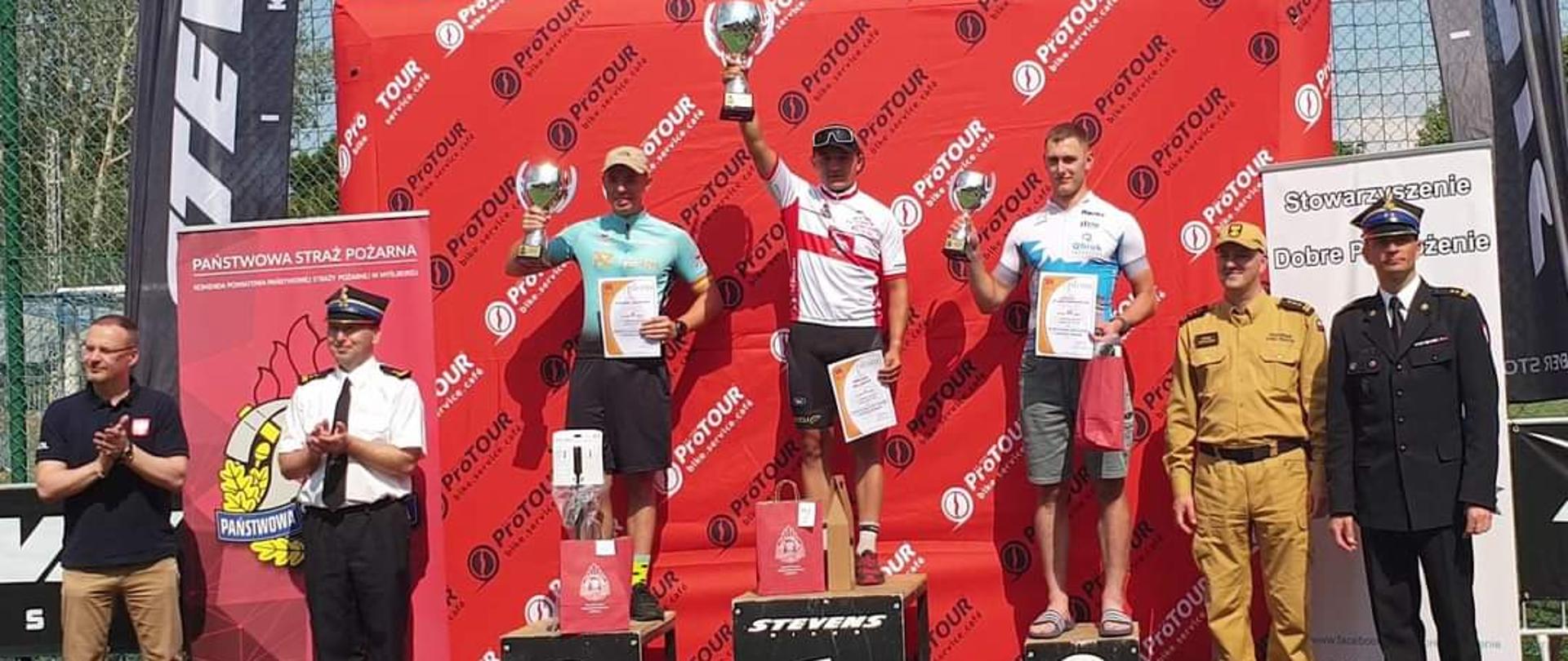 Strażacy z pucharami na podium 3 pierwsze miejsca