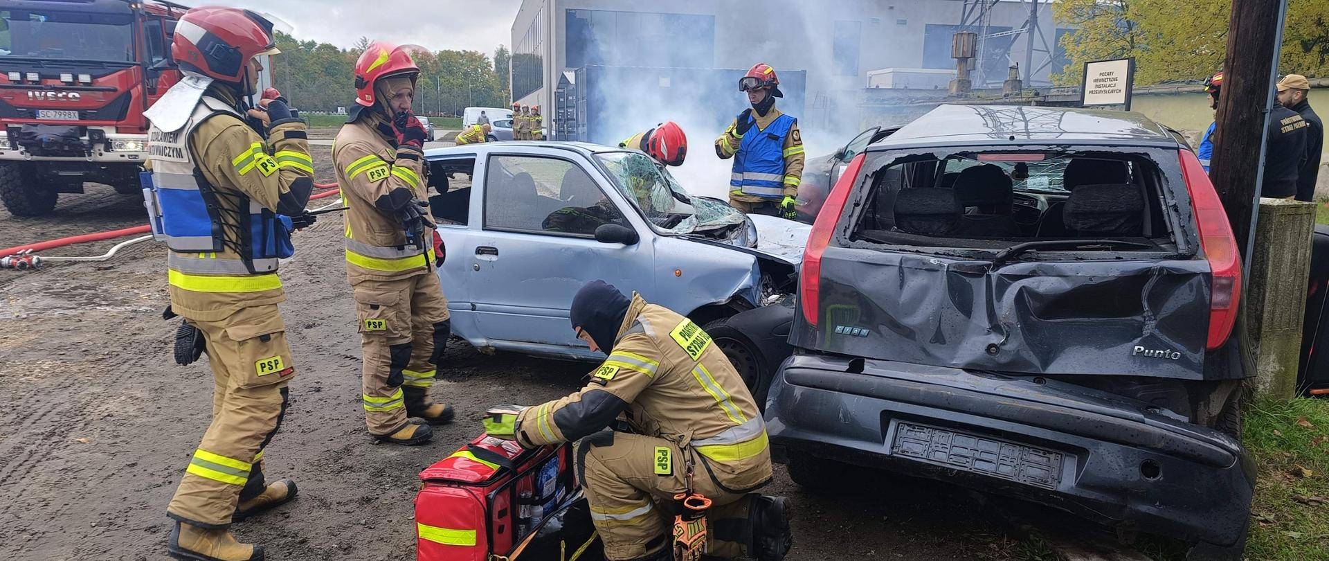 Poligon Centralnej Szkoły PSP na którym ustawione zostały dwa samochody osobowe symulujące wypadek, przy którym działania podejmują ćwiczący strażacy