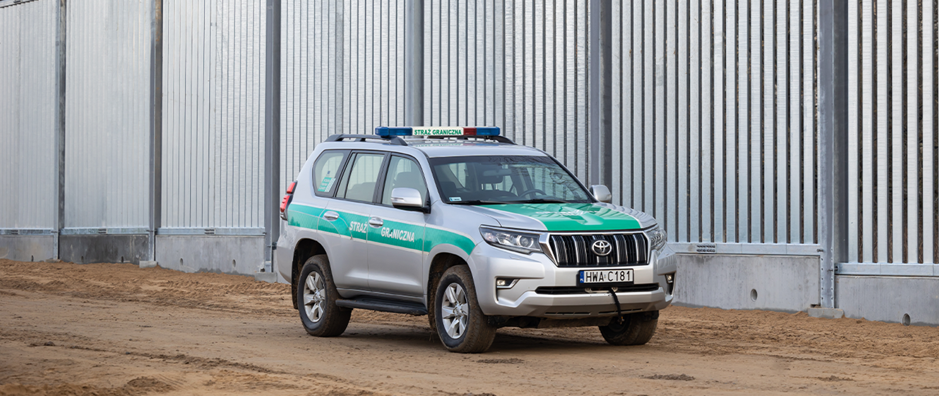 Samochód Straży Granicznej na tle zapory