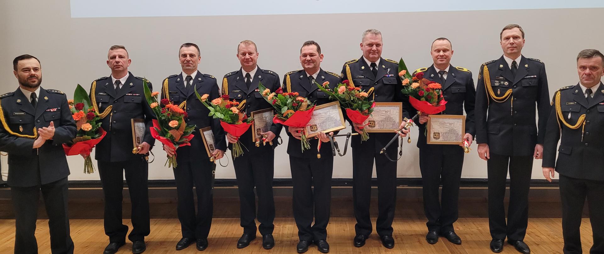 Pamiątkowe zdjęcie uczestników uroczystej zbiórki z okazji pożegnania przechodzących na emeryturę funkcjonariuszy 