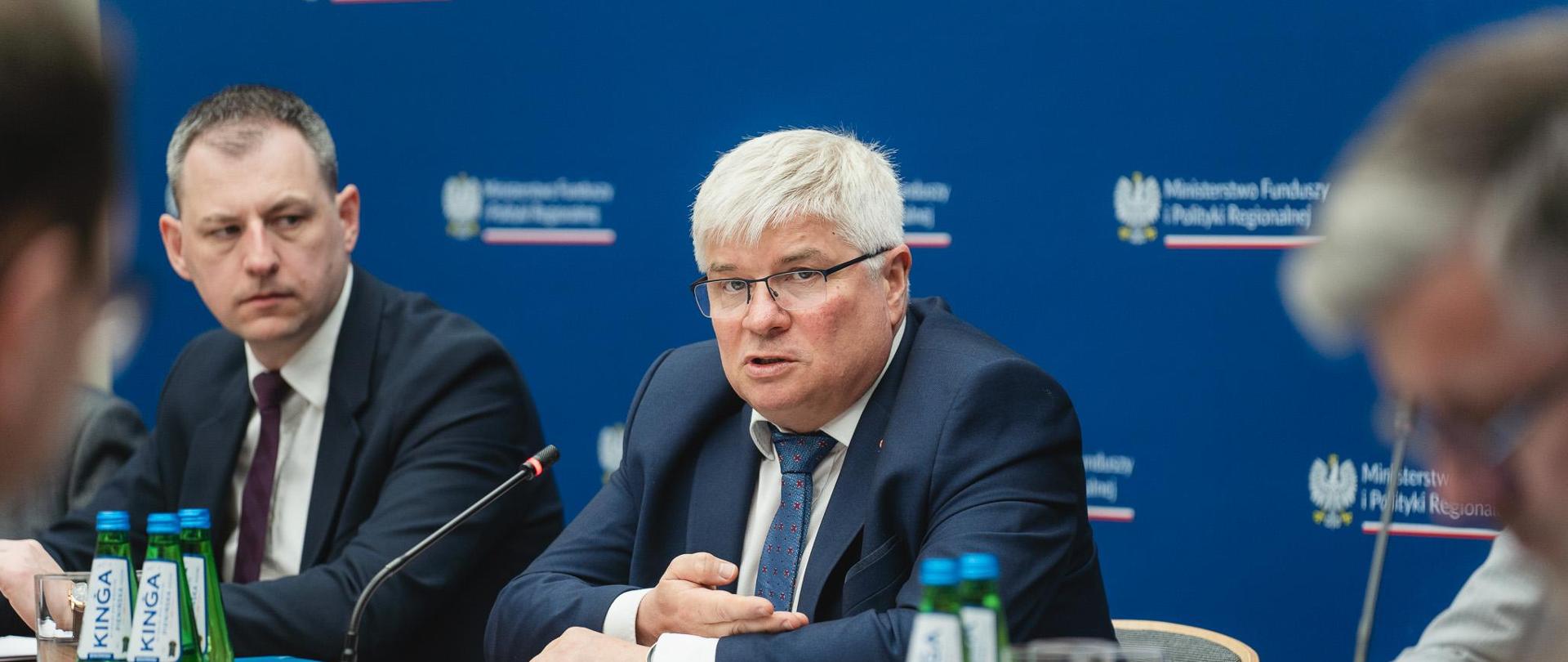 Dwóch mężczyzn siedzi przy stole konferencyjnym