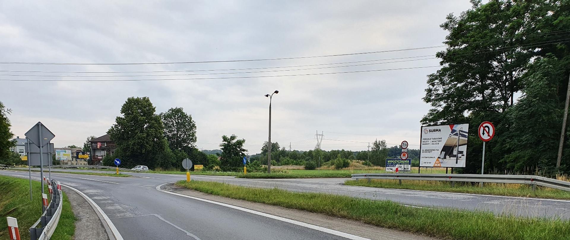 skrzyżowanie na DK52 w Czańcu, na zdjęciu widoczne jest skrzyżowanie trzywlotowe na drodze jednojezdniowej dwupasowej, zaopatrzonej w bariery ochronne, w tle widoczne są zabudowania