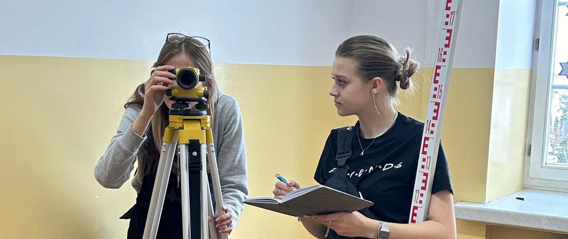 Uczennice podczas nauki działania niwelatora 