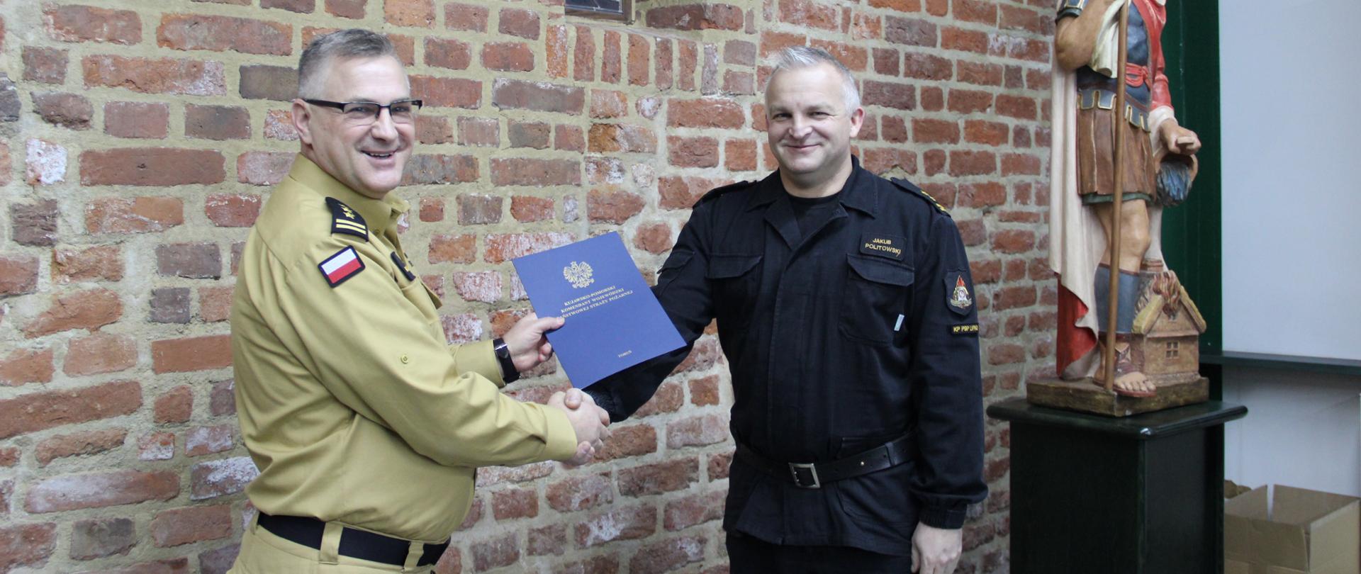 Na zdjęciu kujawsko-pomorski komendant wojewódzki PSP przekazuje nagrodę zastępcy komendanta powiatowego psp w Lipnie