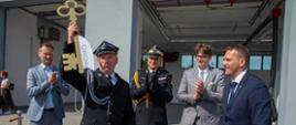 Druh Ochotniczej Straży Pożarnej w Kosakowie trzyma symboliczny klucz do jednostki obok stoją przedstawiciele władz wojewódzkich samorządowych oraz pomorski komendant wojewódzki Państwowej Straży Pożarnej.