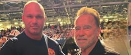 Na zdjęciu widoczny st. str. Przemysław Brzoza oraz Arnold Schwarzenegger – organizator zawodów. W tle publiczność.