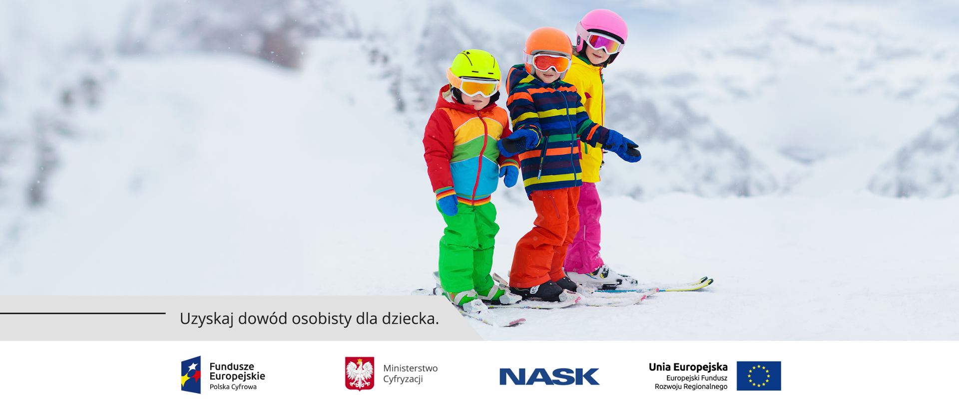 Trójka dzieci na nartach na śniegu, ubranych w kaski oraz gogle narciarskie.