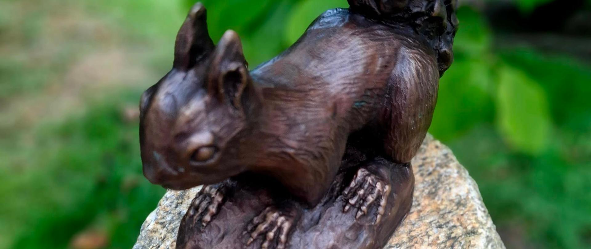 Figurka wiewiórki z brązu zamocowana na granitowym kamieniu