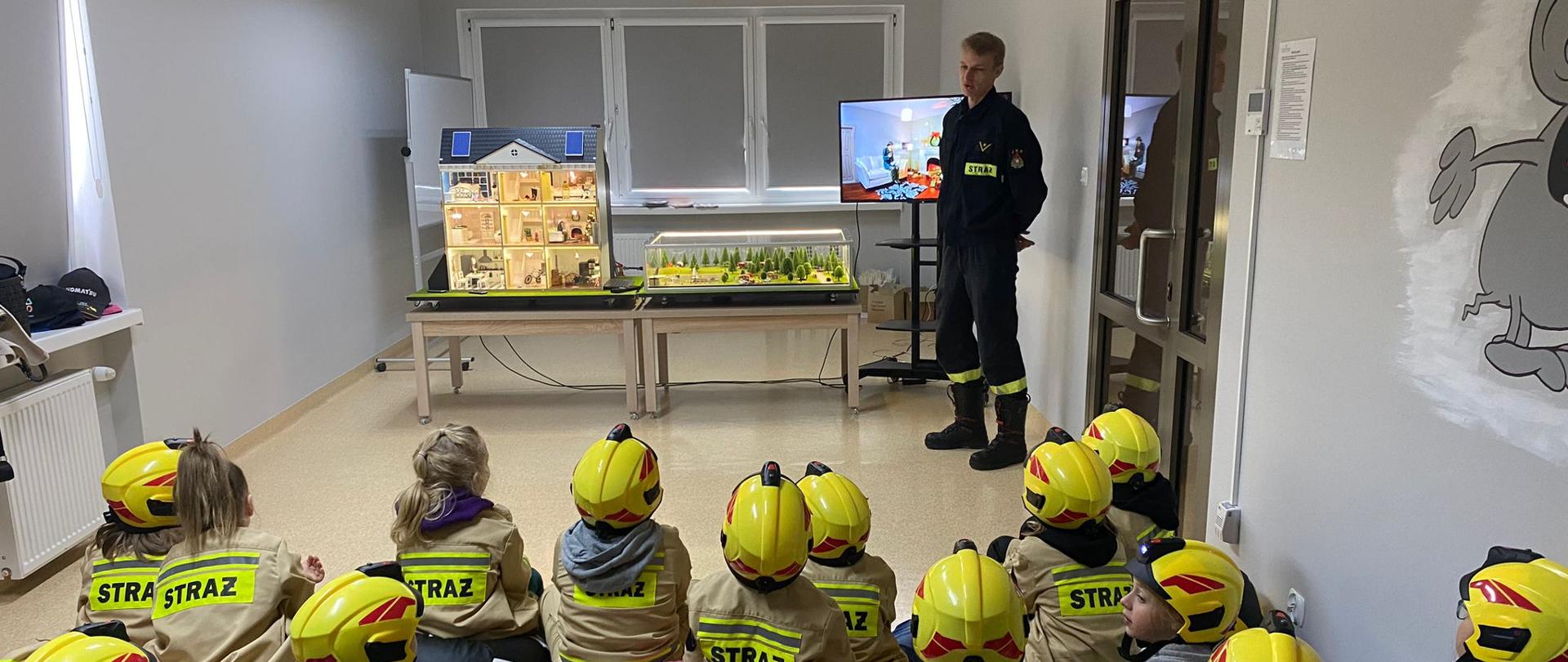 Dzieci słuchają jak strażak opowiada o pożarach jakie mogą powstać w domu 