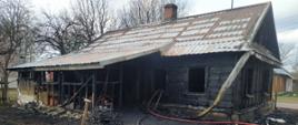 Czesciowo spalony dom drewniany.