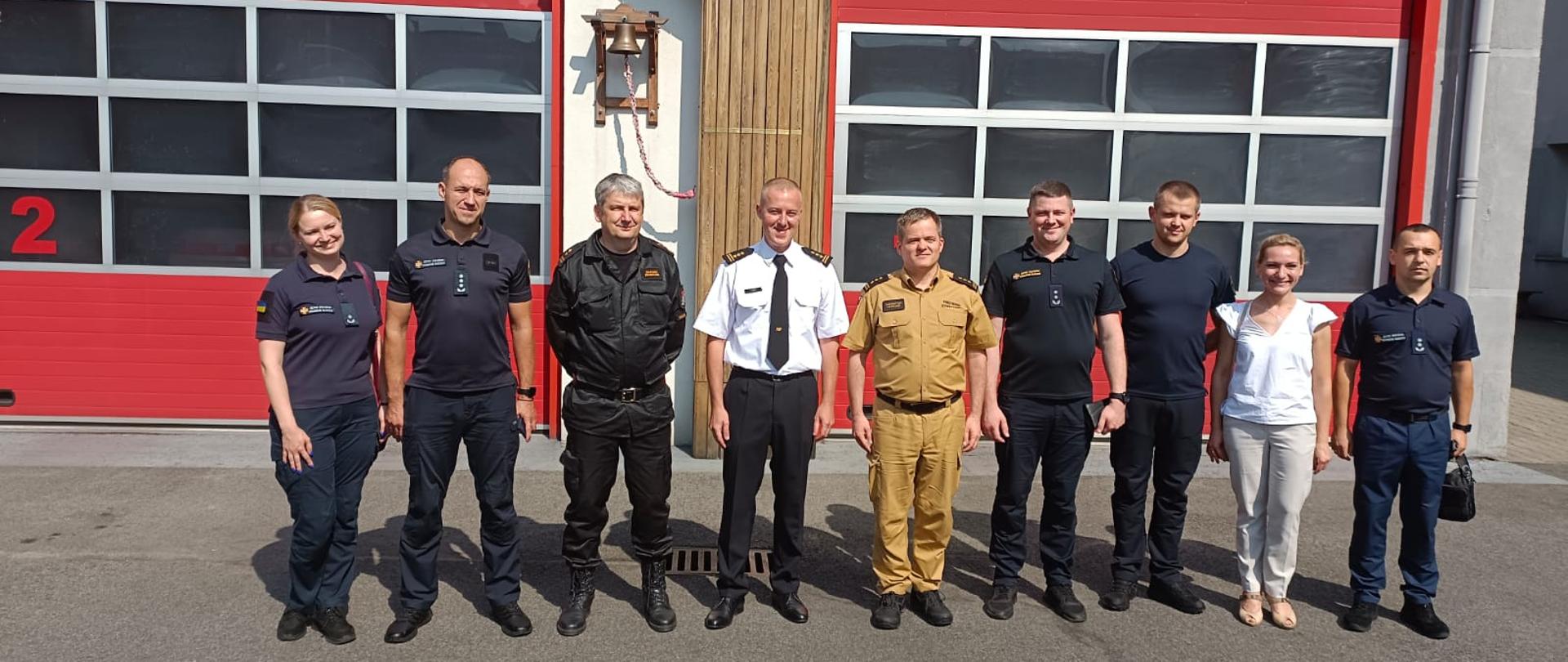 Zdjęcie przedstawia delegację ukraińskiej Państwowej Służby Ukrainy na tle bram garażowych Komendy Miejskiej Państwowej Straży Pożarnej w Chorzowie