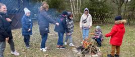 Wizyta Ukraińskich dzieci w JRG - Strażacy i dzieci z opiekunami podczas pieczenia kiełbasek na ognisku
